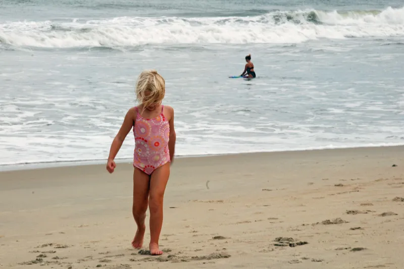 Wide sandy beach on Hatteras Island with gentle waves, clear water, and open coastline stretching into the distance