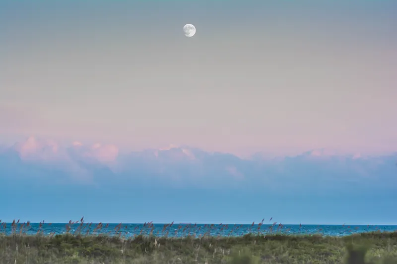 Vivid sunset over Hatteras Island with warm colors reflecting off the water and sky along the Outer Banks