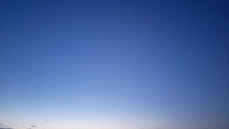 Hyades and Pleiades star clusters visible in the pre-dawn sky over the Outer Banks beach
