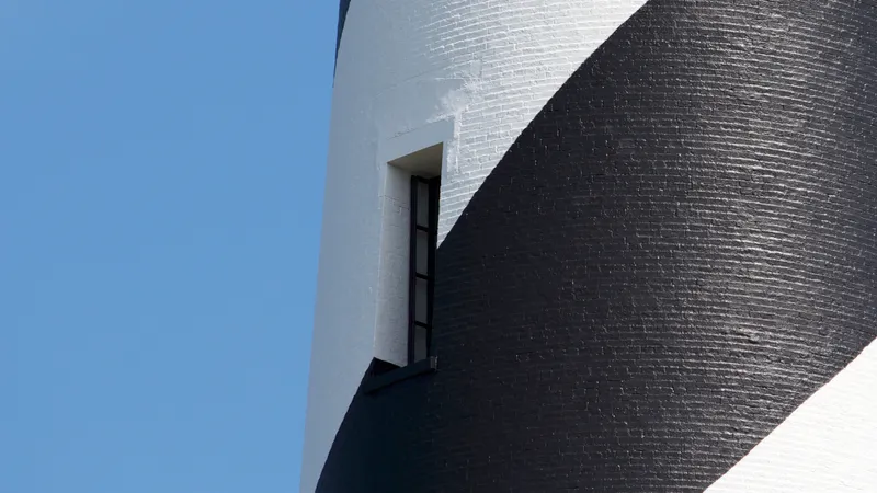 Cape Hatteras Lighthouse with its distinctive black and white spiral pattern against a blue sky