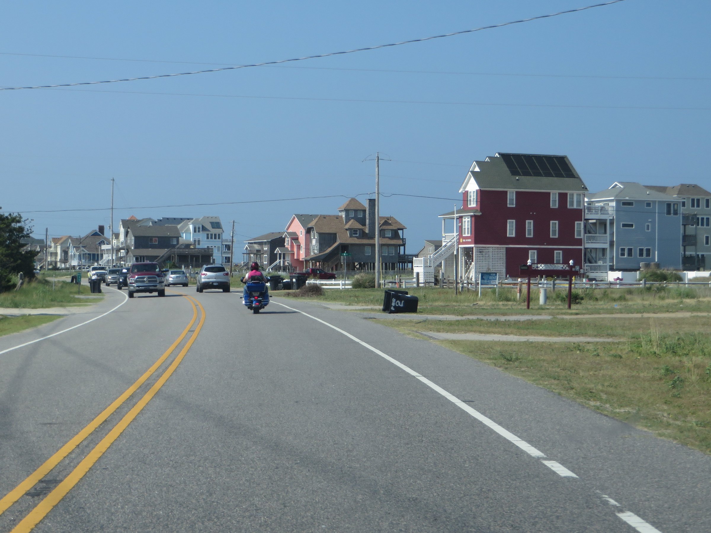 Highway 12 passing through Rodanthe on the Outer Banks with beach houses, dunes, and the Atlantic Ocean visible