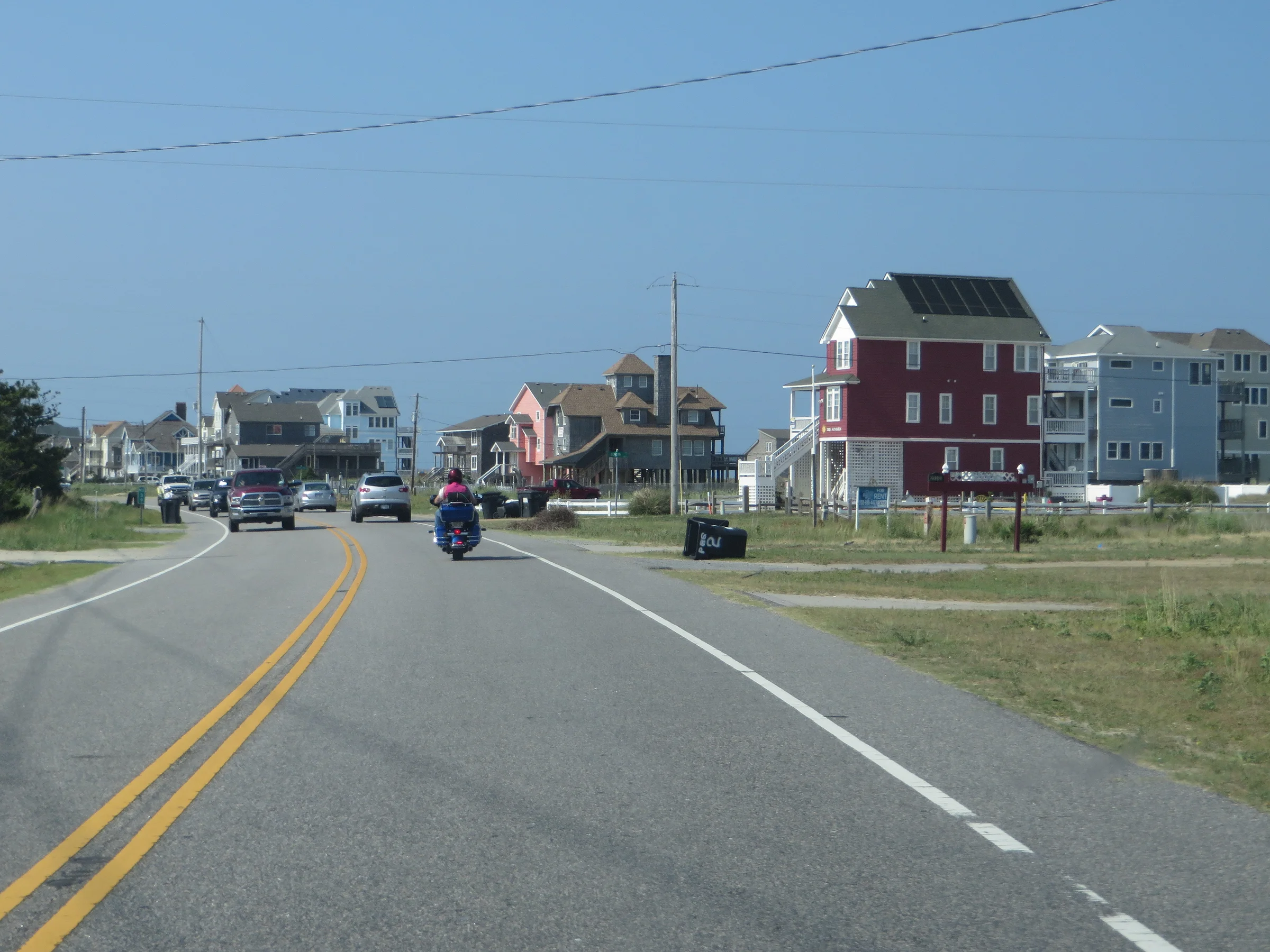 Highway 12 passing through Rodanthe on the Outer Banks with beach houses, dunes, and the Atlantic Ocean visible