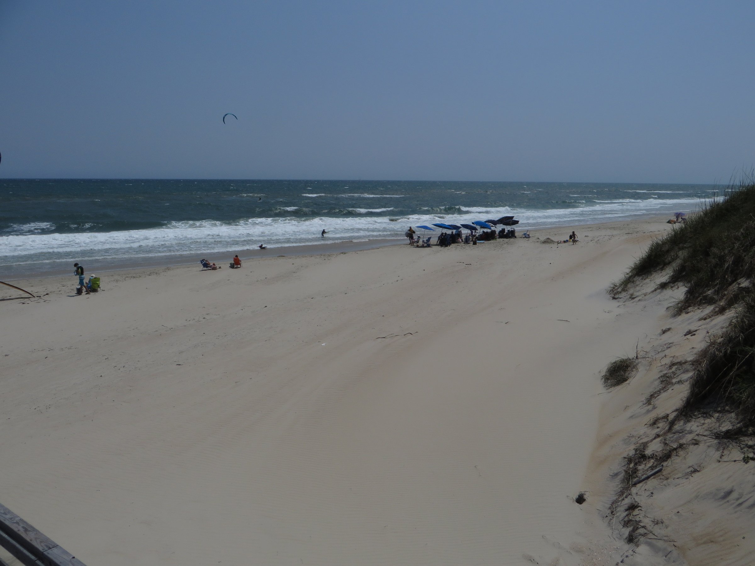 Wide open beach along Cape Hatteras National Seashore near Salvo with ocean waves, sand, and sea grass on the dunes